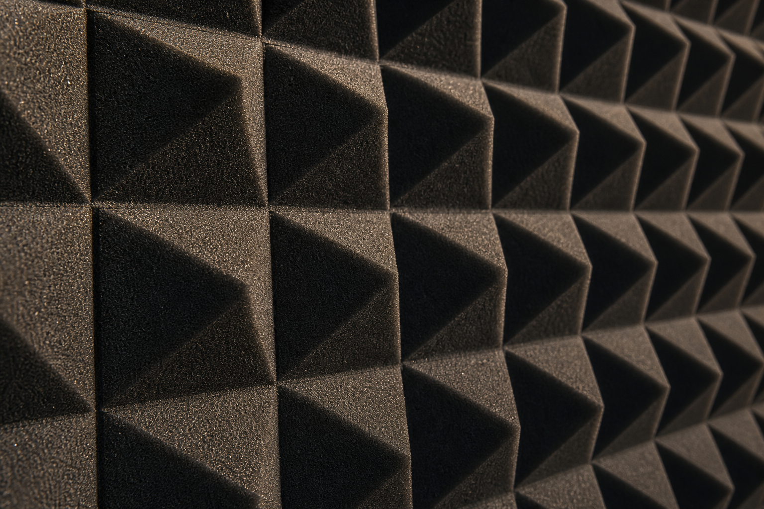 Close-up detail of acoustic foam panel wall texture in warm light